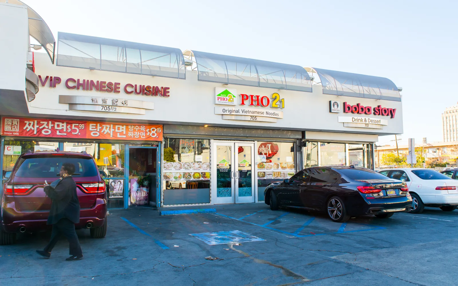 Storefronts of a Chinese restaurant, Vietnamese restaurant, and boba tea shop in a food plaza on South Western Avenue